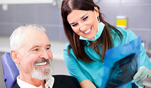 Dentist explaining diagram to elderly patient